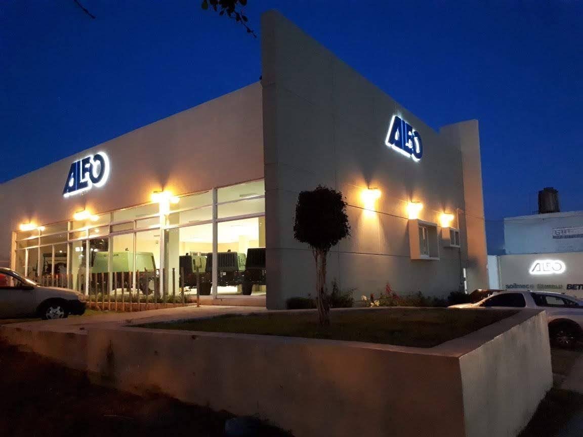 Fachada corporativa con letras de canal iluminadas, de noche
