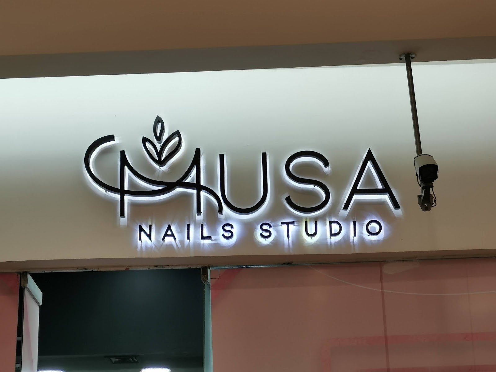 Letras negras con halo de luz en local de plaza