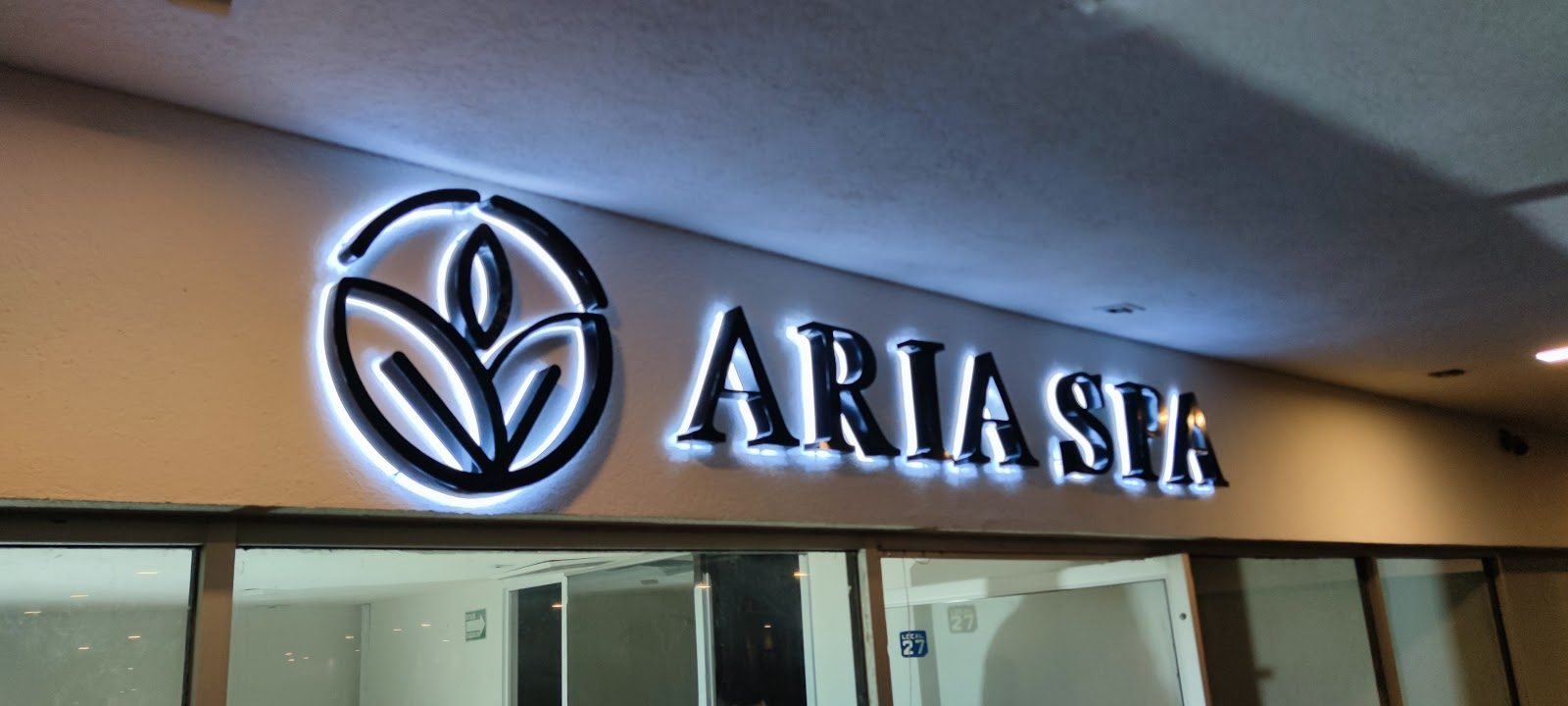Letras negras con halo de luz blanca en fachada de spa