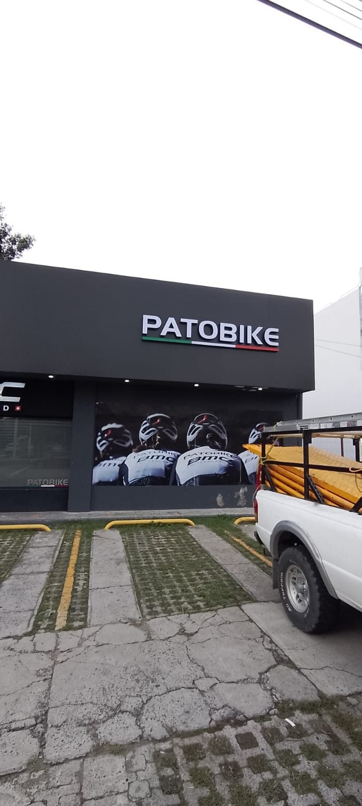 Fachada completa revestida en panel de aluminio gris con letras