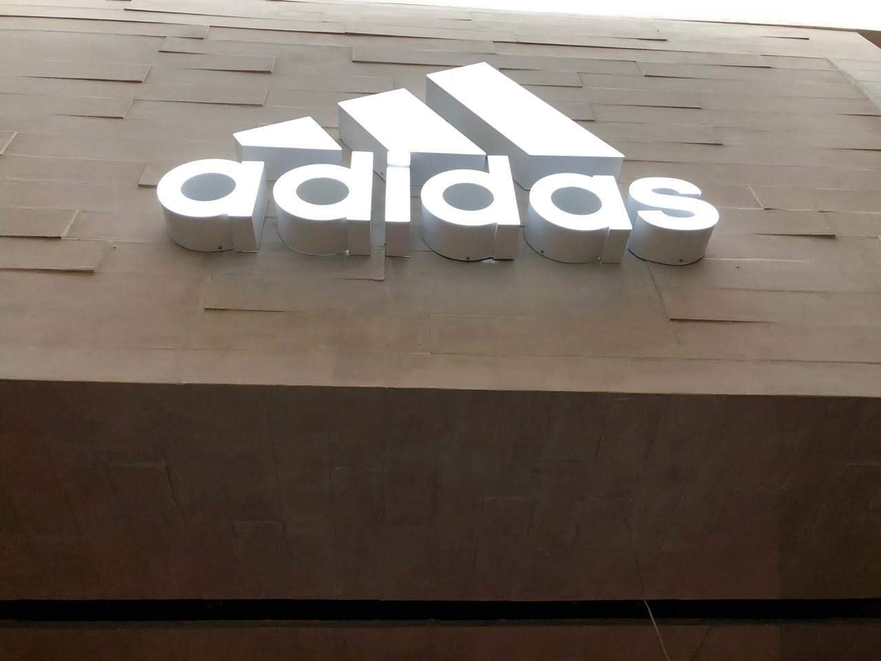 Logotipo y letras 3D blancas sobre muro de piedra