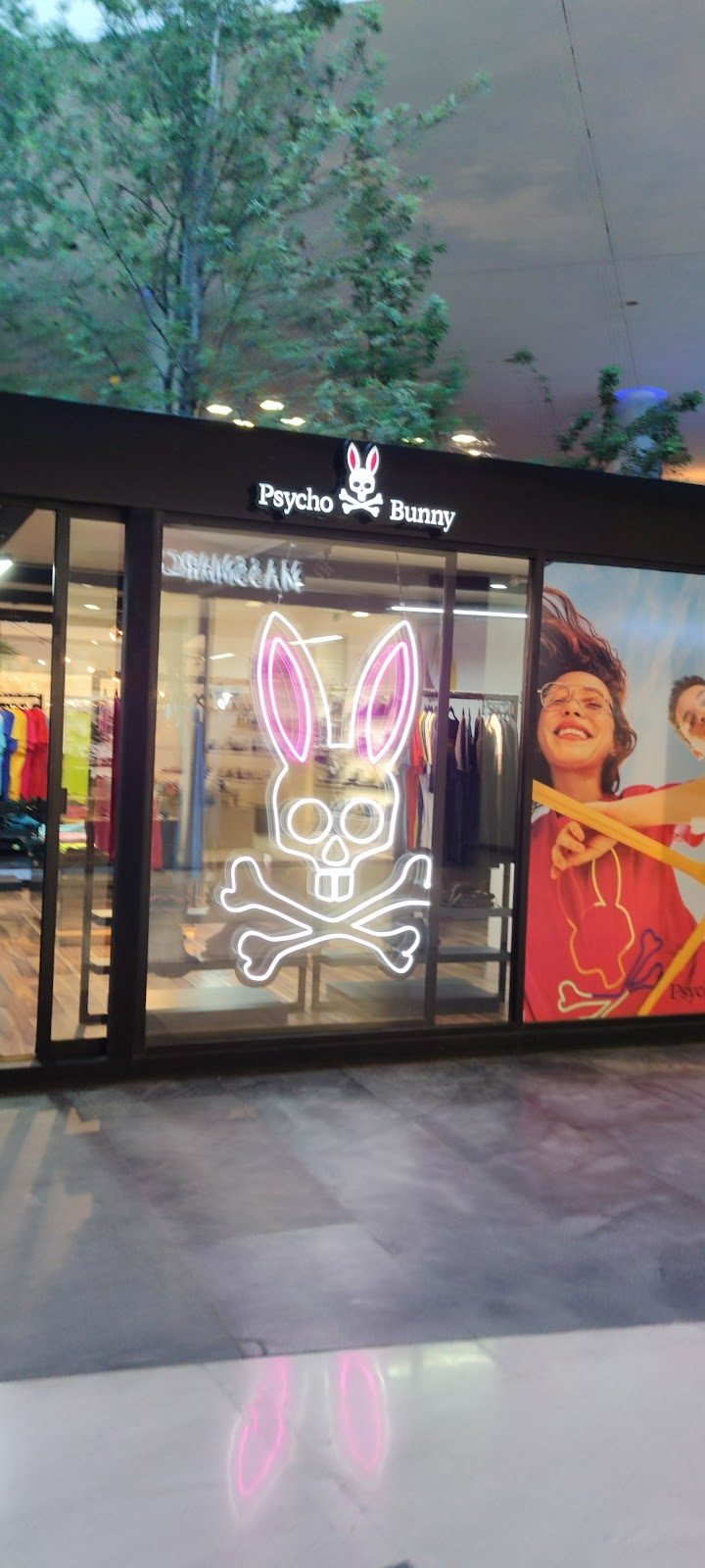 Letras y logotipo iluminados sobre fachada negra de tienda