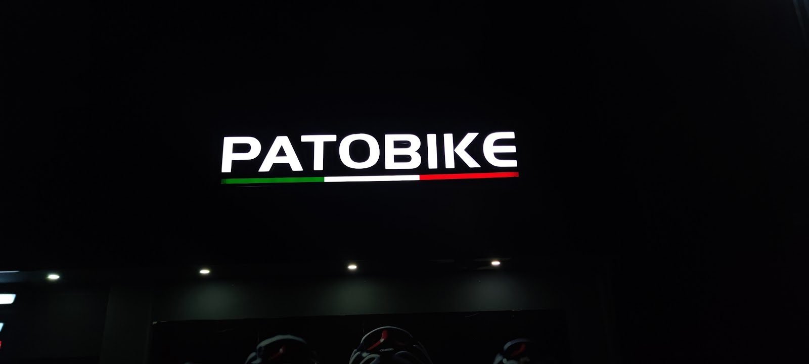Letras iluminadas blancas con línea tricolor en fachada