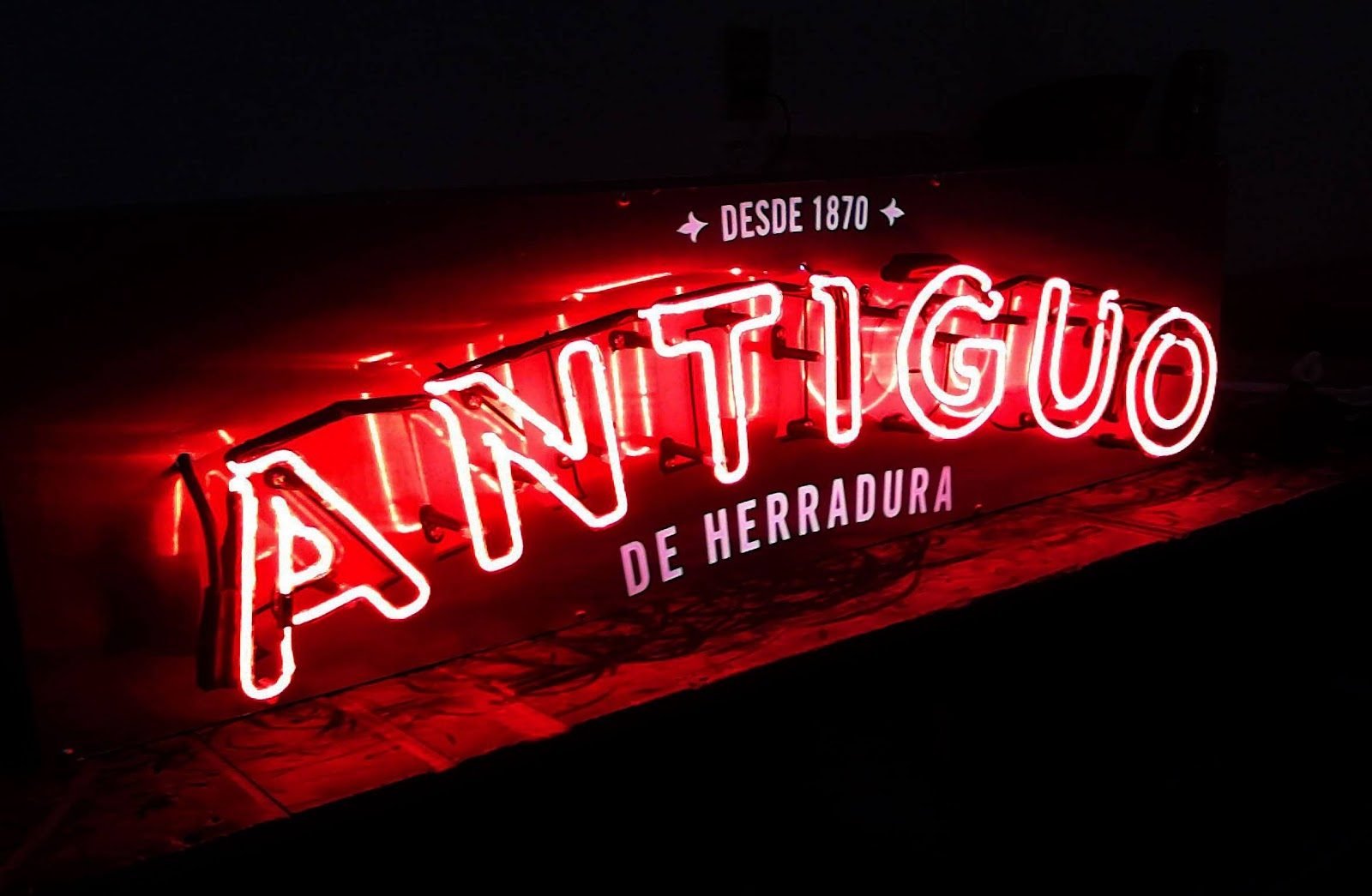 Letrero de neón rojo y blanco de una marca de tequila