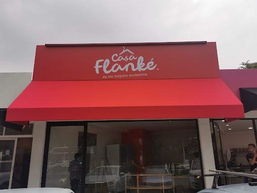 Toldos y estructuras: Casa Flanké, toldo rojo con marca rotulada sobre fachada comercial